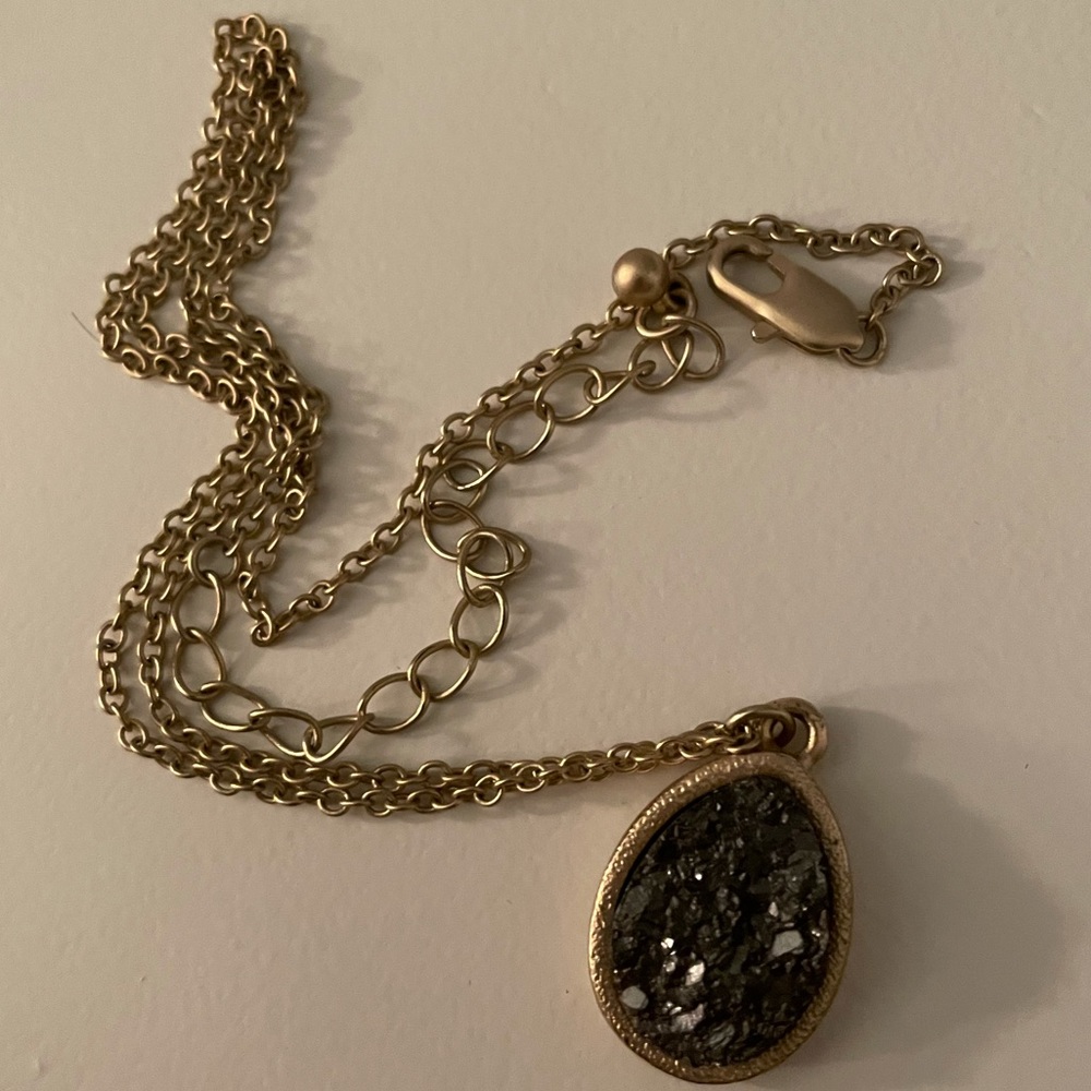 Gold colored necklace with black natural stone